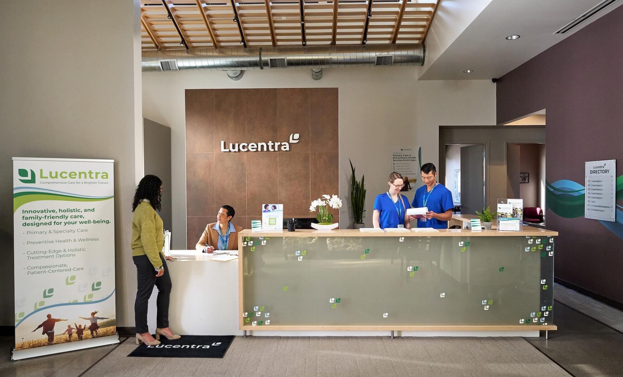 Reception area of Lucentra clinic, featuring three staff members interacting with clients.
