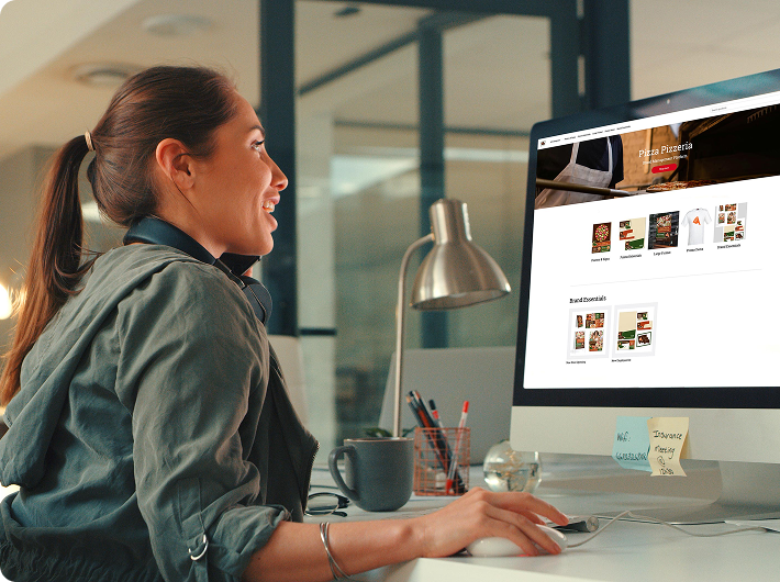 Woman smiling while browsing Pizza Pizzeria website on a desktop computer